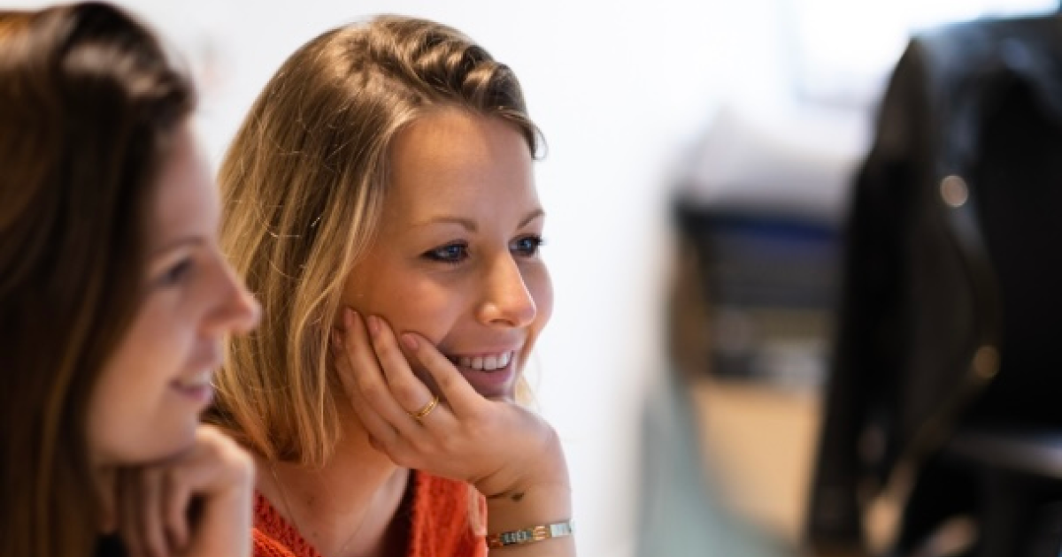 Twee vrouwen die hun hoofd laten rusten op hun hand