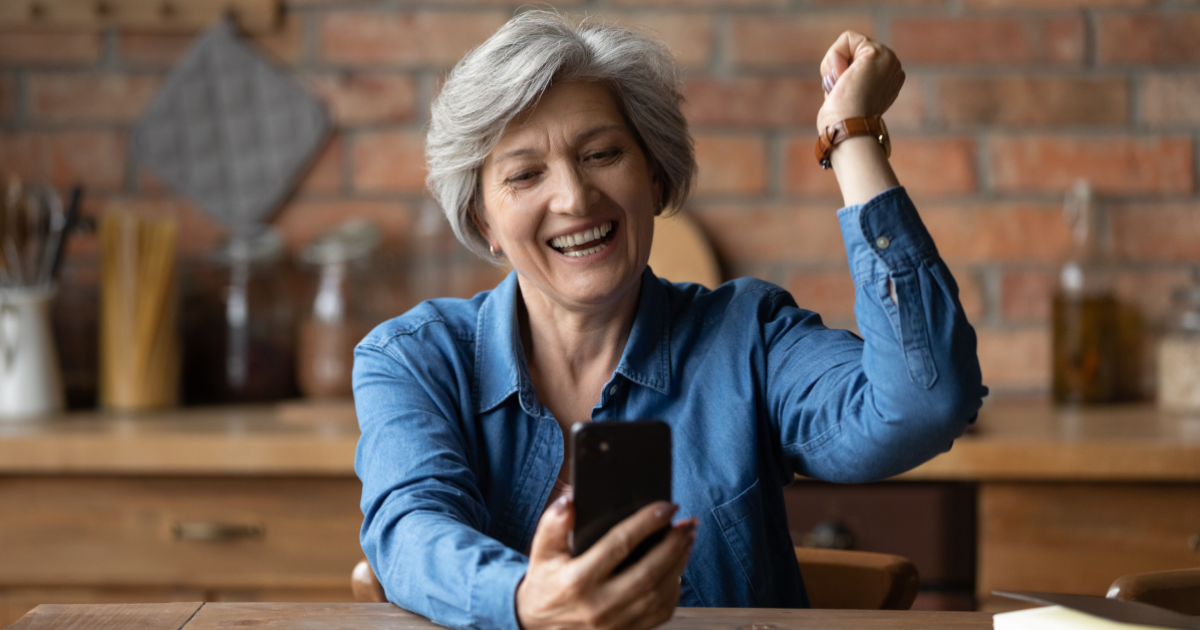 Une dame retraitée qui a trouvé avec enthousiasme un flexi-job grâce à un smartphone