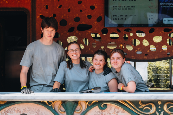 Vier studenten en flexi's die werken achter de bar van Tomorrowland