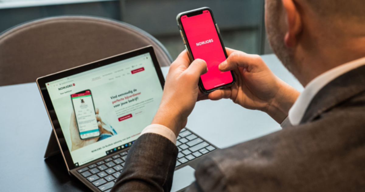 Een werkgever die de NOWJOBS-app raadpleegt via smartphone en laptop